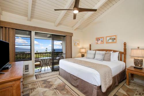 a bedroom with a bed and a television and a balcony at Wailea Ekolu Village - CoralTree Residence Collection in Wailea