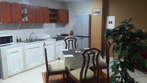 - une cuisine avec une table, des chaises et un évier dans l'établissement APARTA-HOTEL YINNAM ARRIETA, à San Andrés