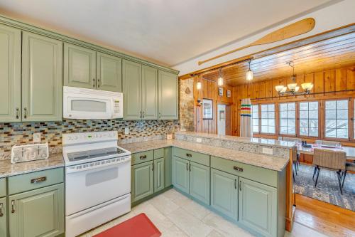 a kitchen with green cabinets and a white microwave at Family-Friendly Lake Waubesa Home Boat and Swim! in McFarland