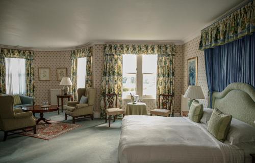 ein Schlafzimmer mit einem Bett und ein Wohnzimmer in der Unterkunft Kinloch House Hotel in Blairgowrie