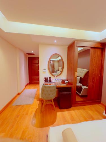 a room with a table and a mirror and a bed at Granada Hotel in An Najaf