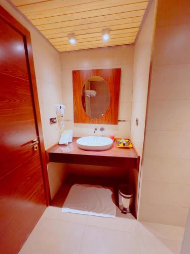 a bathroom with a sink and a mirror at Granada Hotel in An Najaf