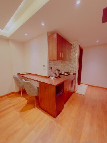 a kitchen with a counter and chairs in a room at Granada Hotel in An Najaf