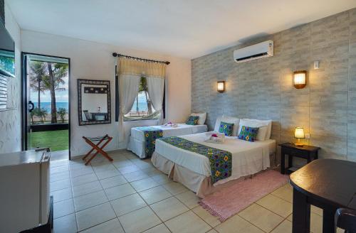 1 dormitorio con 2 camas y vistas al océano en Pousada dos Coqueiros, en Porto de Galinhas