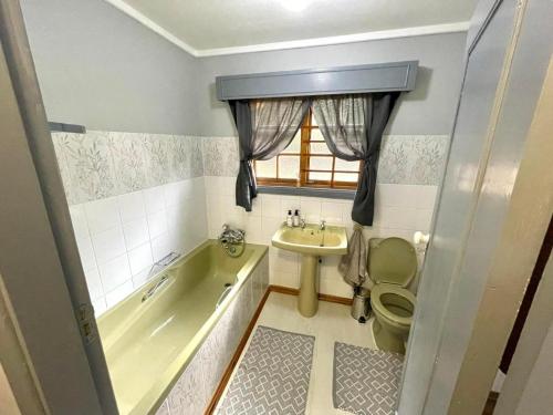 a bathroom with a tub and a toilet and a sink at The Hedge at Dullstroom Cottage in Dullstroom