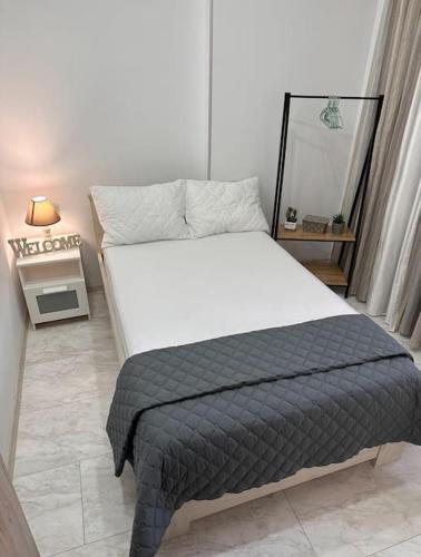a bedroom with a bed with a white mattress and a mirror at Sunny Dreams in Nea Kalikratia