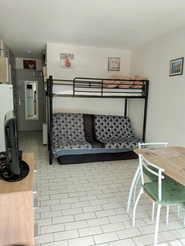 a room with two bunk beds and a table at TROP COOL in Cap d'Agde