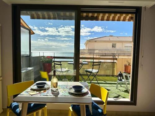 d'une table à manger avec vue sur l'océan depuis une fenêtre. dans l'établissement The view-Centre- Clim -Parking-vue mer-plage, à Menton