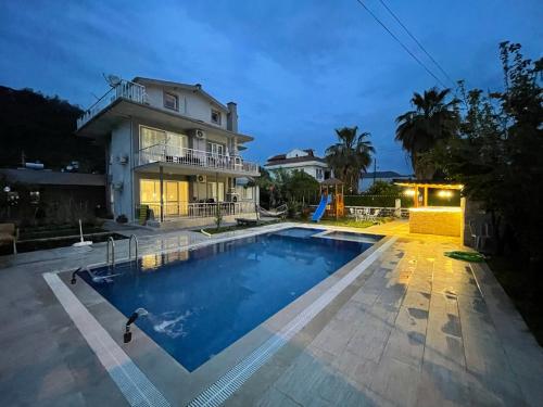 a large swimming pool in front of a house at Duranapart Fethiye in Fethiye