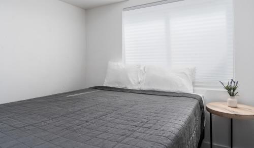 a white bedroom with a bed and a table at 8 Beds 2 Full Kitchens Fenced HUGE Yard & Parks! in Saratoga Springs