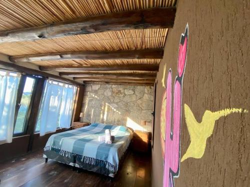 a bedroom with a bed and a painting on the wall at Cabañas Cabra Corral in Coronel Moldes