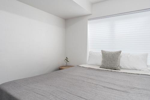 a white bedroom with a large bed and a window at 8 Beds 2 Full Kitchens Fenced HUGE Yard & Parks! in Saratoga Springs