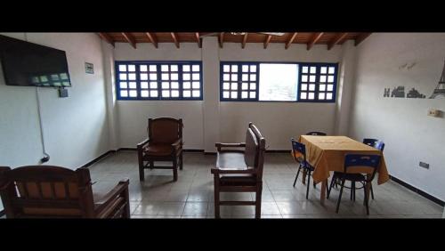 a room with a table and chairs and two windows at HOTEL SAN JUDAS in Santa Fe de Antioquia