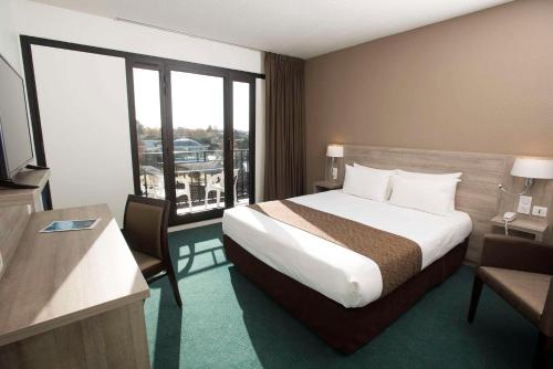 サン・ポール・レ・ダックスにあるBrit Hotel du Lacのベッドと窓が備わるホテルルーム