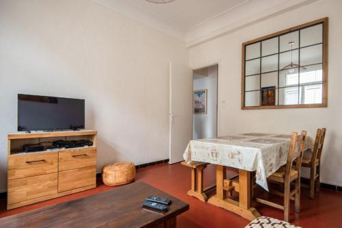 un salon avec une table et une télévision dans l'établissement Bright Apartment in Marseille, à Marseille