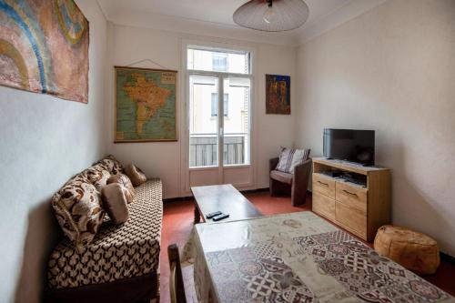 un salon avec un canapé et une télévision dans l'établissement Bright Apartment in Marseille, à Marseille