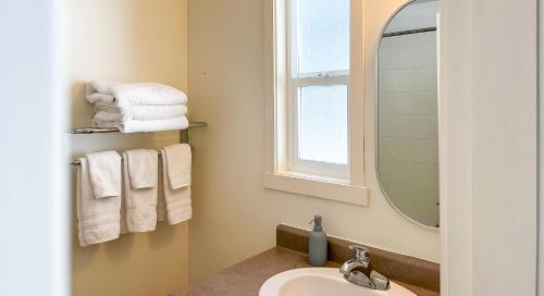 uma casa de banho com lavatório, espelho e toalhas em The Stonewater em Madeira Park