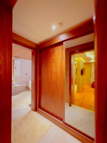 a room with a large glass door and a bathroom at Granada Hotel in An Najaf