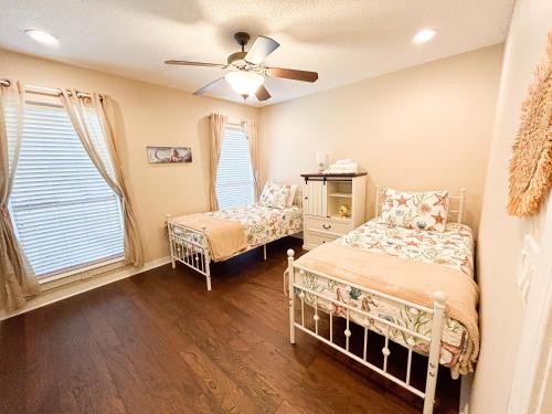 a bedroom with two beds and a ceiling fan at FairHaven Beach Retreat in Navarre