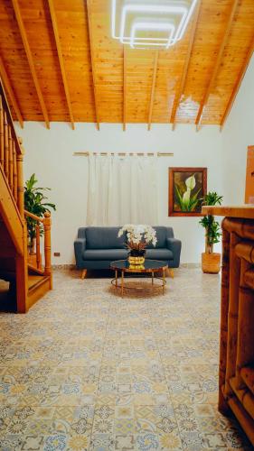 a living room with a blue couch and a table at Eco Hotel Terrabella in Santa Elena