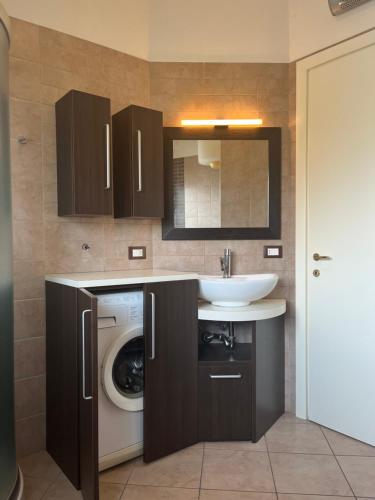 een badkamer met een wastafel en een wasmachine bij La Stella Blu in Gatteo a Mare