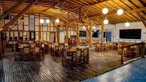 a dining room with wooden tables and chairs at Eco Hotel Terrabella in Santa Elena