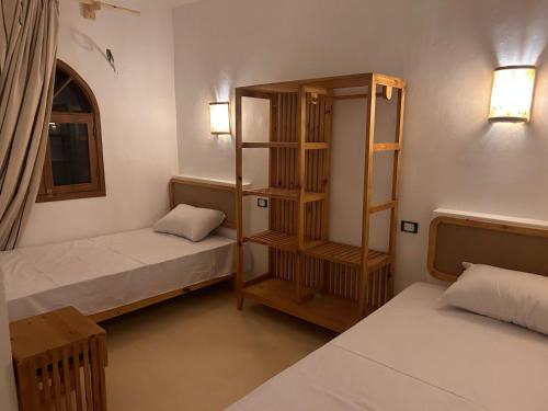 Zimmer mit 2 Betten und Bücherregal in der Unterkunft Tokyo house in Dahab