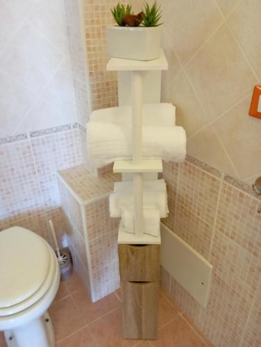 a stack of towels in a bathroom with a toilet at Il Portico Rosa in Cuglieri
