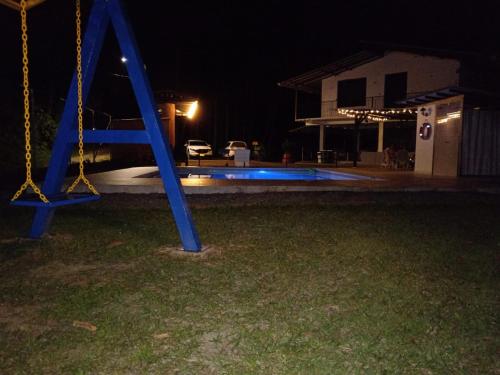 a blue swing in a yard at night at Finca hotel el porvenir in Quimbaya