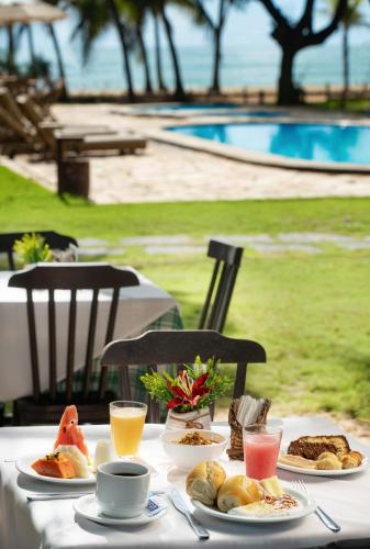 Pousada dos Coqueiros في بورتو دي غالينهاس: طاولة مليئة بأطباق الطعام والمشروبات