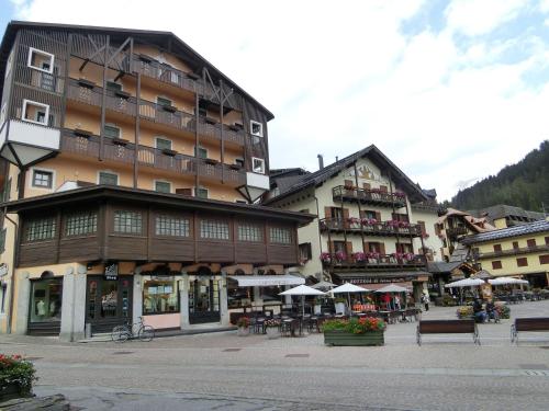 een groot gebouw in een stad met tafels en stoelen bij Sport Campiglio Apartment in Madonna di Campiglio