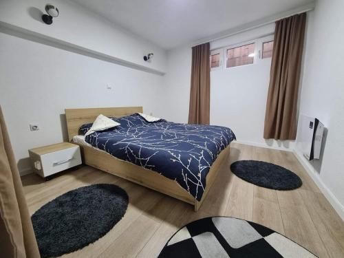 a bedroom with a bed and two rugs on the floor at Apartments Gjakove in Gjakove