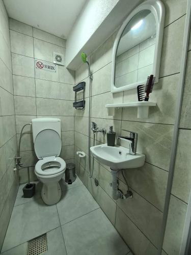 y baño con aseo y lavamanos. en Apartments Gjakove, en Gjakove