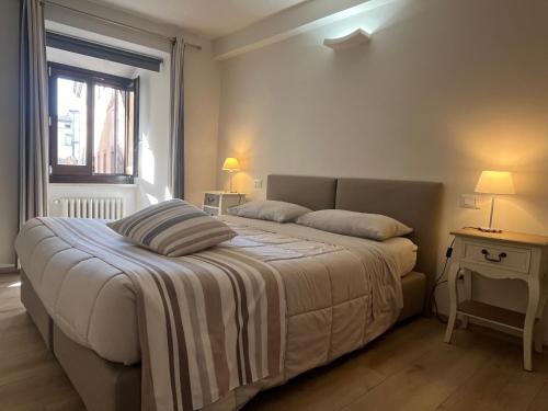 a bedroom with a bed with a striped blanket on it at Home in Orvieto - Corso Cavour in Orvieto