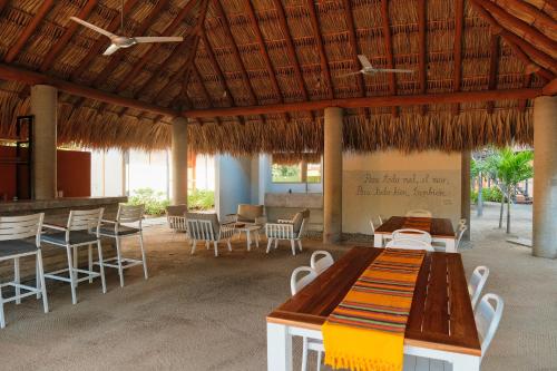 a pavilion with tables and chairs and a table and chairs at Casa Akaw in Temalhuacán