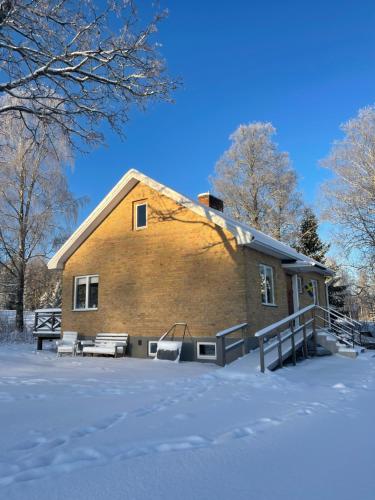 a house with snow on the ground in front of it at Familjehuset Sunnemo in Sunnemo