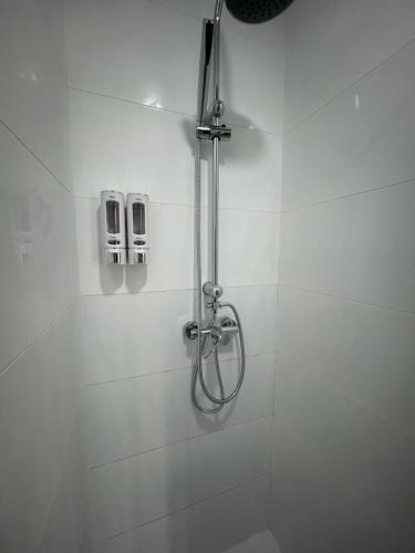 a shower in a bathroom with white tiles at Apartamento Verdial 2 in Cala del Moral