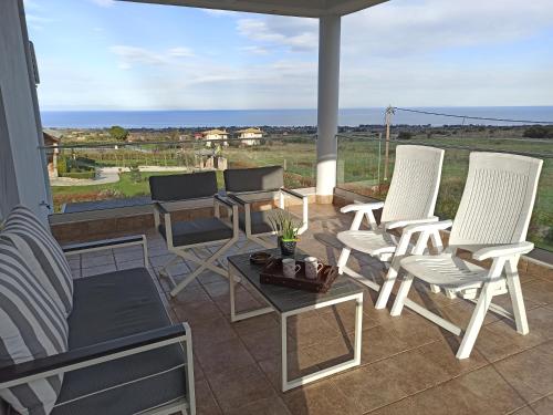 a patio with white chairs and a table and a view at Zeusplace Olympous Riviera Villa 1 in Litochoro