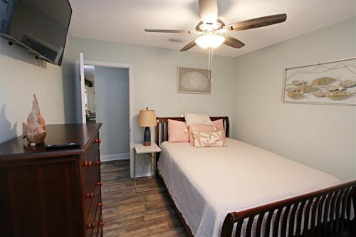 een slaapkamer met een bed en een plafondventilator bij The Peaceful One in Foley
