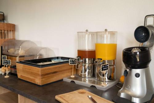 eine Küchentheke mit einem Mixer und einem Glas Saft in der Unterkunft Brit Hôtel Confort - La Tour Blanche in Saint-Yrieix-la-Perche