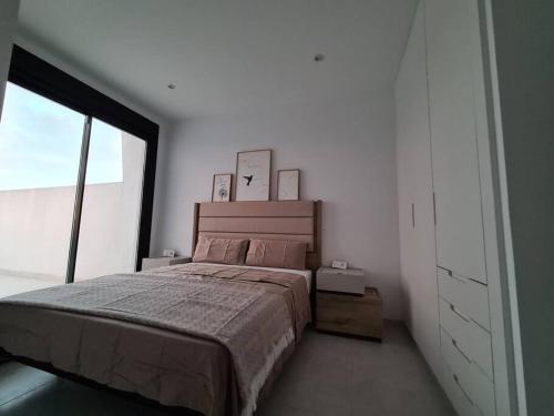 1 dormitorio con cama y ventana grande en Villa Palmera 2, en San Pedro del Pinatar