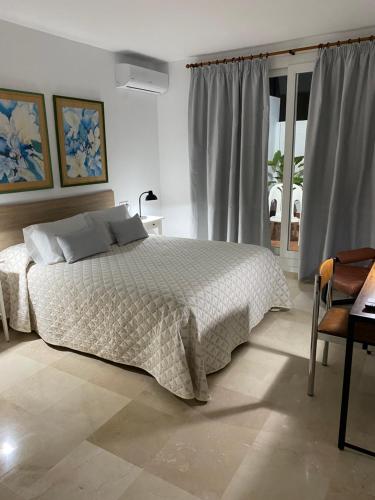 a bedroom with a bed and a table and a window at APARTAMENTO SAN JOSE in Palma del Río