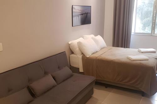 sala de estar con cama y sofá en Studio em Copacabana Menos de 100 metros da Praia, en Río de Janeiro