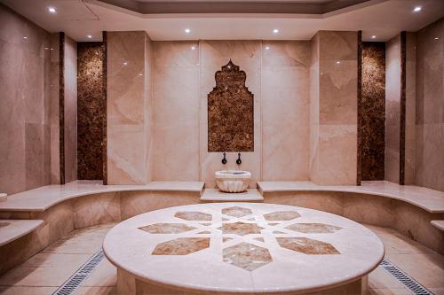 a large room with a table in a room with marble walls at Granada Hotel in An Najaf