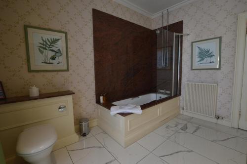 a bathroom with a bath tub and a toilet at Kinloch House Hotel in Blairgowrie
