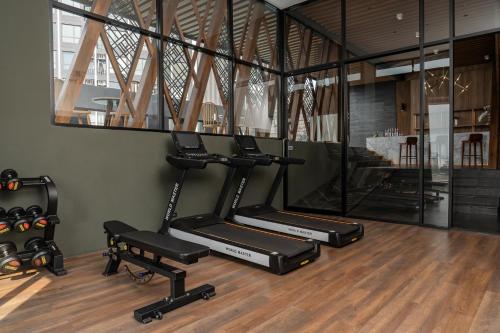 a gym with two treadmills and a mirror at Zayn Hotel Bangkok - Airport Link Access in Bangkok