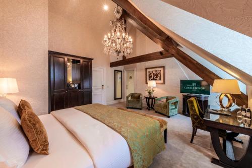 a bedroom with a large bed and a chandelier at Grand Hotel Casselbergh in Bruges