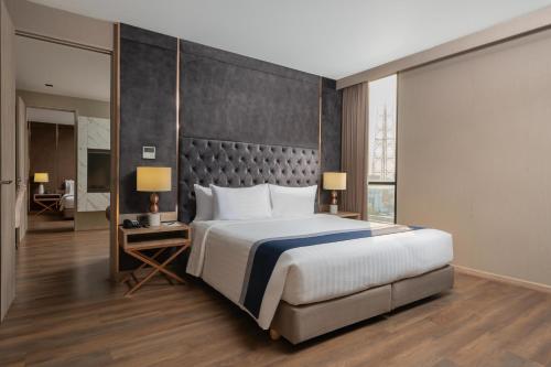 a bedroom with a large bed and a large window at Zayn Hotel Bangkok - Airport Link Access in Bangkok