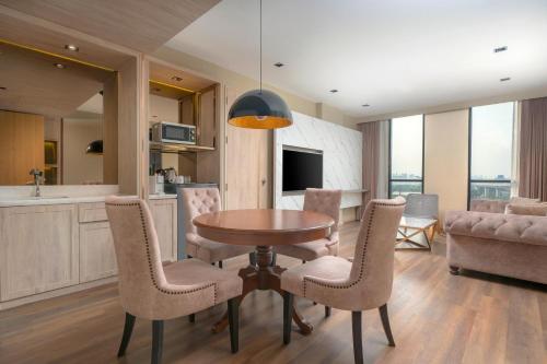 a kitchen and dining room with a table and chairs at Zayn Hotel Bangkok - Airport Link Access in Bangkok
