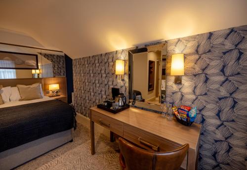 a bedroom with a bed and a desk with a mirror at Brisbane House Hotel in Largs